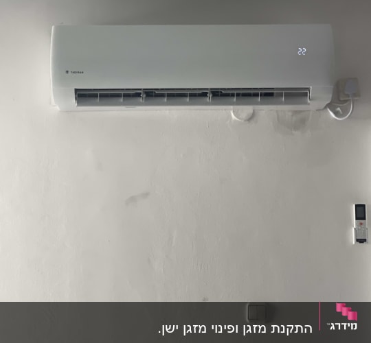 מזגן מותקן על קיר עם שלט רחוק